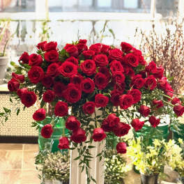 Large bouquet of red roses in a tall pedestal vase