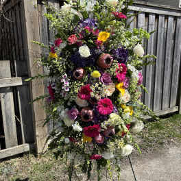 Large standing floral spray with mixed roses, gerberas, and lilies