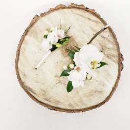 White orchid corsages on a wood slice background