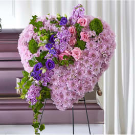 Heart-shaped floral spray with pink and purple flowers on an easel