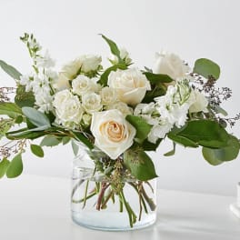 White roses and stock in a clear glass vase