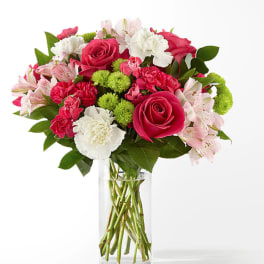 Pink roses, carnations, and alstroemeria in a clear glass vase