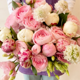 Large bouquet of pink and white flowers held in front of a person