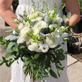 White bridal bouquet with round blooms and trailing greenery