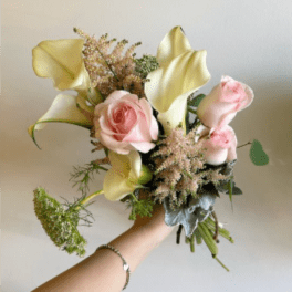 Handheld bouquet with pink roses and pale yellow calla lilies