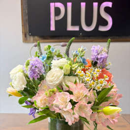 Mixed bouquet of pink alstroemeria, white roses, and yellow tulips in a clear glass cylinder vase