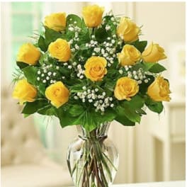 Bouquet of yellow roses with baby's breath in a clear glass vase