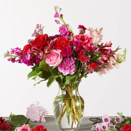 Mixed pink and red flower bouquet in a clear glass vase