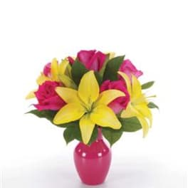 Pink roses and yellow lilies arranged in a small bright pink vase