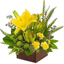 Yellow lilies and green blooms arranged in a wooden box