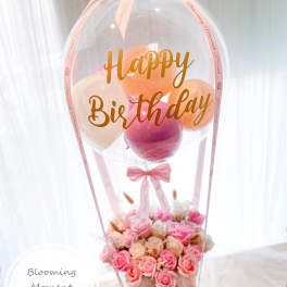 Pink birthday balloon arrangement with roses in a box