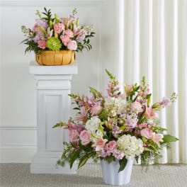 Pink and white floral arrangements in a basket and white vase