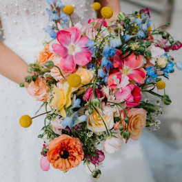 Bride holding a colorful bouquet of roses and mixed blooms