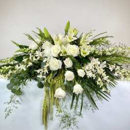 White floral casket spray with roses and lilies