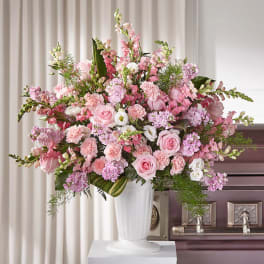 Large pink and white floral arrangement in a white vase