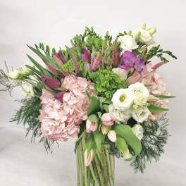 Mixed pink, white, and green bouquet in a clear glass vase
