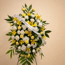 Standing floral wreath of yellow and white flowers on an easel