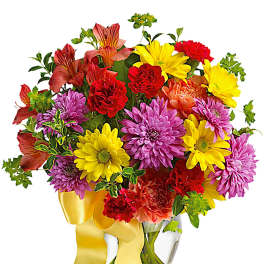 Colorful mixed bouquet in a clear glass vase with a yellow ribbon
