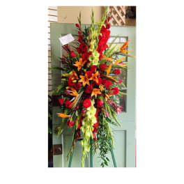 Tall standing floral spray with red, orange, and green flowers