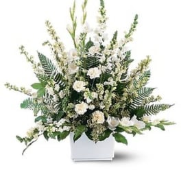 White floral arrangement in a white rectangular vase