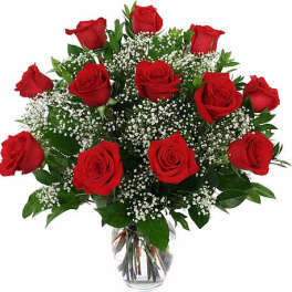 Bouquet of red roses with baby's breath in a clear glass vase