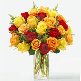 Bouquet of red, yellow, and orange roses in a clear glass vase