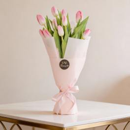 Pink tulips wrapped in pale pink paper with a ribbon