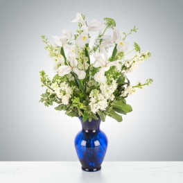 White iris arrangement in a blue glass vase