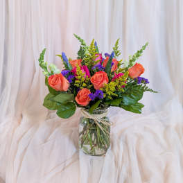 Bouquet of coral and pink roses in a glass vase