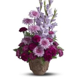 Purple and pink mixed flower arrangement in a decorative pot