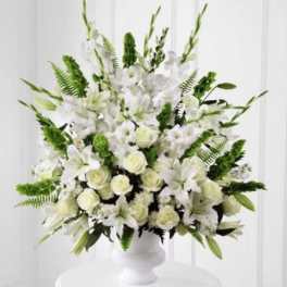 White floral arrangement in a white pedestal vase