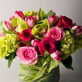 Bouquet of pink roses and tulips in a green wrapped vase