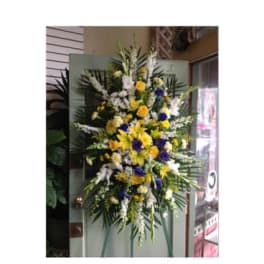 Tall standing floral spray with yellow, white, and purple flowers