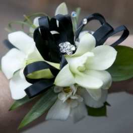 White orchid wrist corsage with black ribbon and rhinestone accents