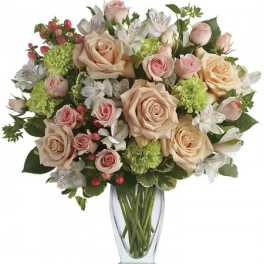 Tall glass vase of peach roses, pink spray roses, green carnations, and white alstroemeria