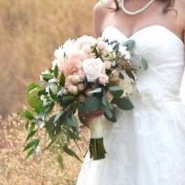 Bride holding a white and blush bouquet with greenery