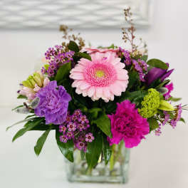 Pink and purple mixed bouquet in a clear glass vase