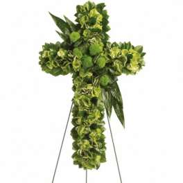 Green floral cross on a metal easel stand with clustered blooms and glossy leaf accents.