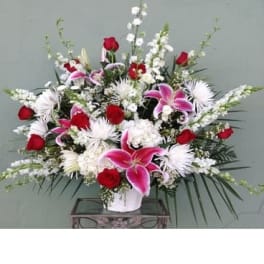Large bouquet of red and pink flowers in a white vase