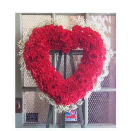 Heart-shaped red floral wreath on an easel