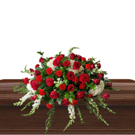 Red roses and white flowers arranged on a casket