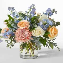 Bouquet of peach and white roses with pink chrysanthemum in a glass vase