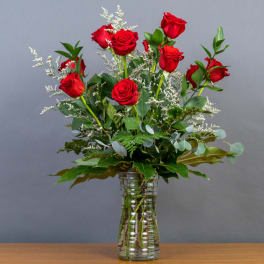 Red roses arranged in a clear glass vase