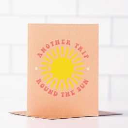 Peach card with a yellow sun and the words "Another Trip Around the Sun"
