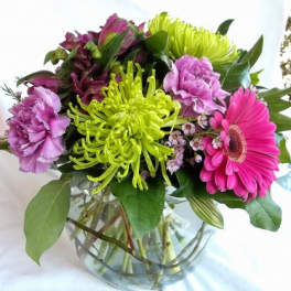 Mixed bouquet of pink and green flowers in a glass vase