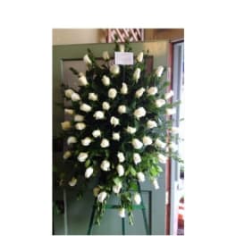 Large standing spray of white roses on an easel