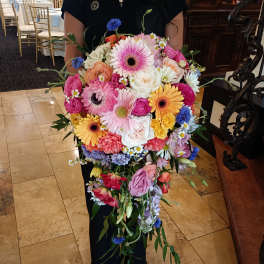 Large colorful bouquet of mixed flowers held by a person