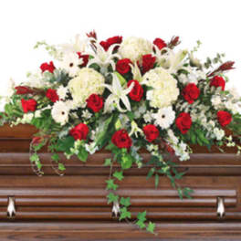 Red and white floral spray on a wooden casket