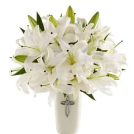 White lily bouquet in a cream vase with a cross emblem