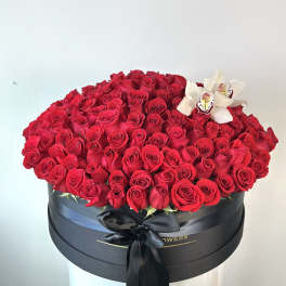 Large box of red roses with white orchids and a black ribbon